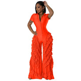 Woman wearing vibrant orange ruffled wide-leg jumpsuit, showcasing streetwear style.